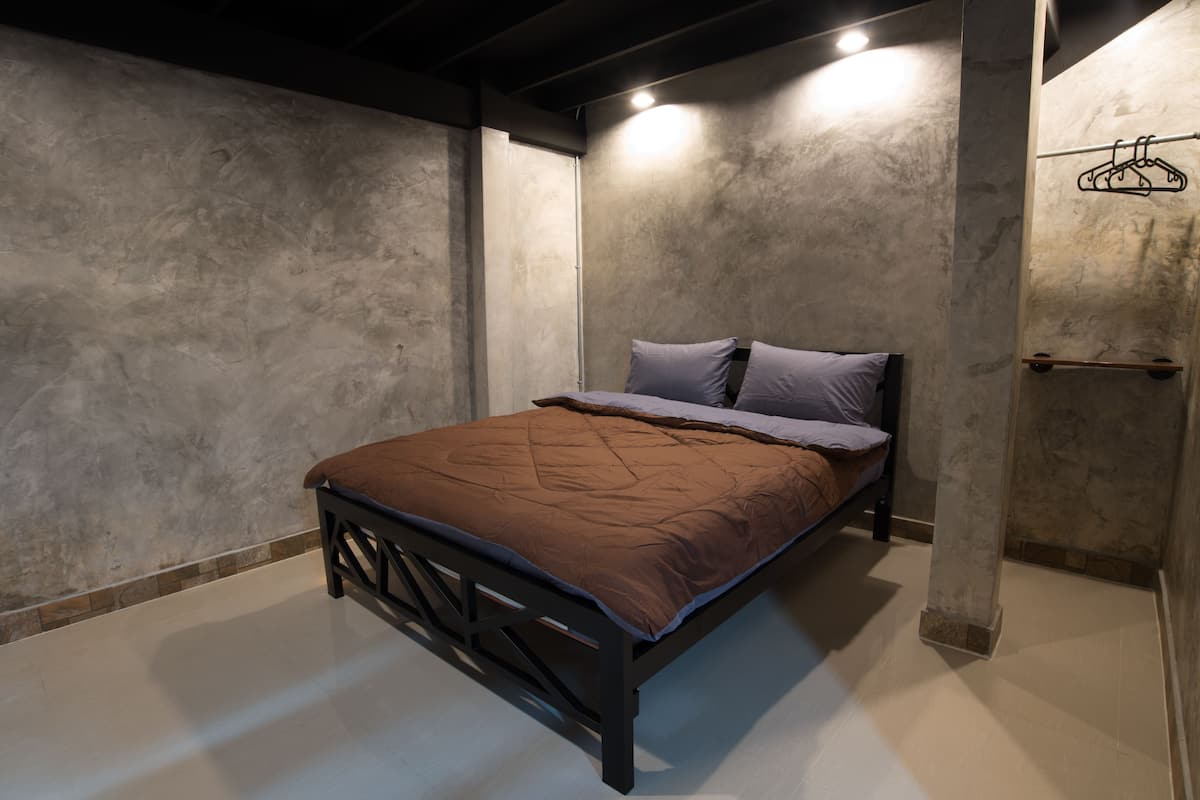 Une chambre à coucher avec un lit, une armoire et un portant à vêtements.
