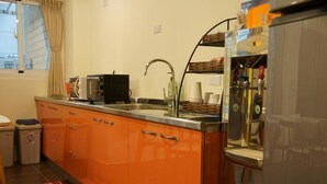 Une cuisine de taille réduite équipée d’un évier, d’un four à micro-ondes et d’un réfrigérateur.