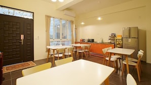 Un espace de vie compact comprenant un coin repas, une kitchenette et une grande fenêtre.