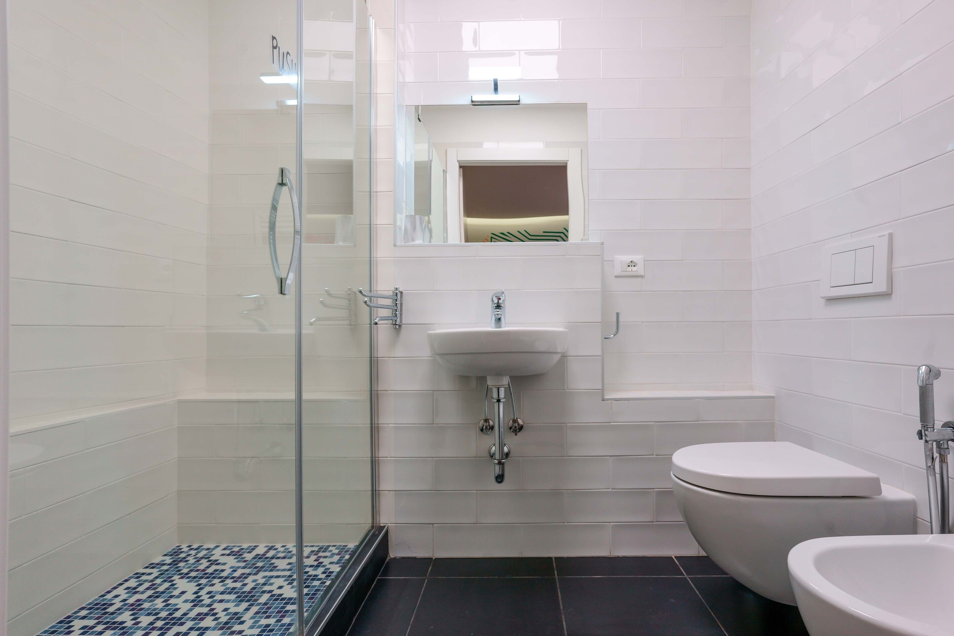 Une salle de bain moderne avec une douche à parois de verre, un lavabo blanc et des toilettes.