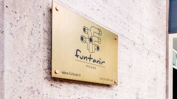 Une plaque portant l’inscription « funtanir ROOMS » et l’adresse d’un site web.