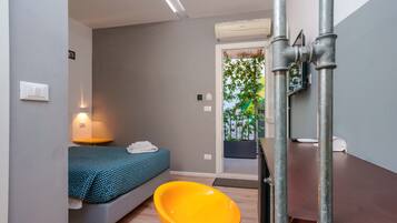Ein modernes Zimmer mit einem Bett, einem gelben Sessel und einem Holztisch.