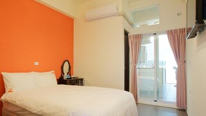 A bedroom with a bed, a nightstand, a mirror, an air conditioning unit, and a sliding glass door leading to an outdoor area.