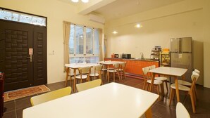 A compact living space with a dining area, kitchenette, and a large window.