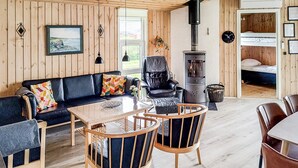 A cozy room with a sofa, chairs, a table, a fireplace, and a bed. - Gorgeous home in Hadsund with kitchen (Hadsund)