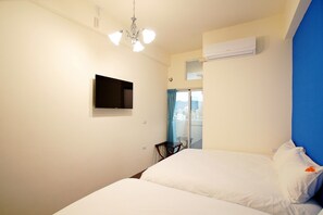 Une chambre d’hôtel équipée d’un lit, d’un téléviseur fixé au mur et d’un appareil de climatisation.
