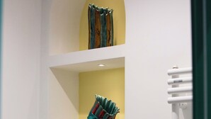 Un mur avec trois étagères où sont exposés divers objets.