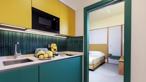 Une cuisine moderne avec des armoires de couleur turquoise, un plan de travail jaune et un four à micro-ondes.