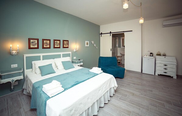 A bedroom with a bed, bedside tables, a chair, a wardrobe, and a bathroom visible through an open door. - Casa Minna (Sant'Agnello)