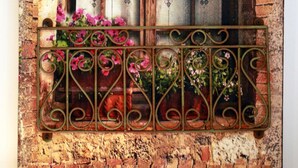 A rustic brick wall with a window and a metal balcony railing. - Casa Minna (Sant'Agnello)