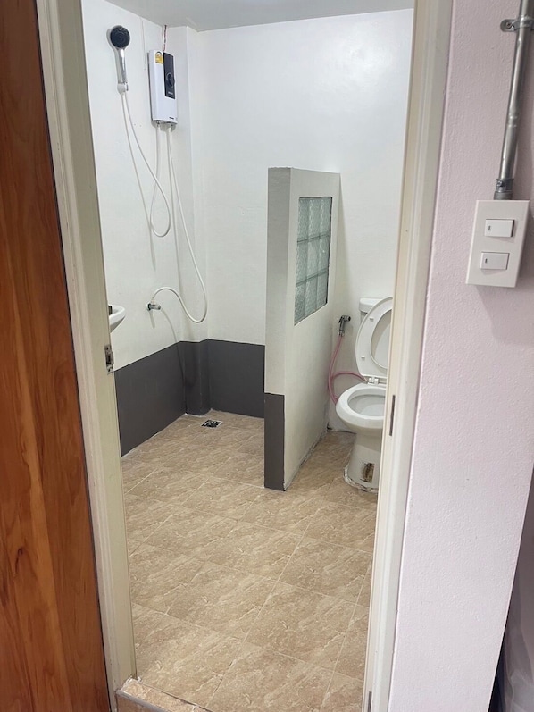 Un baño con inodoro, ducha y lavabo.