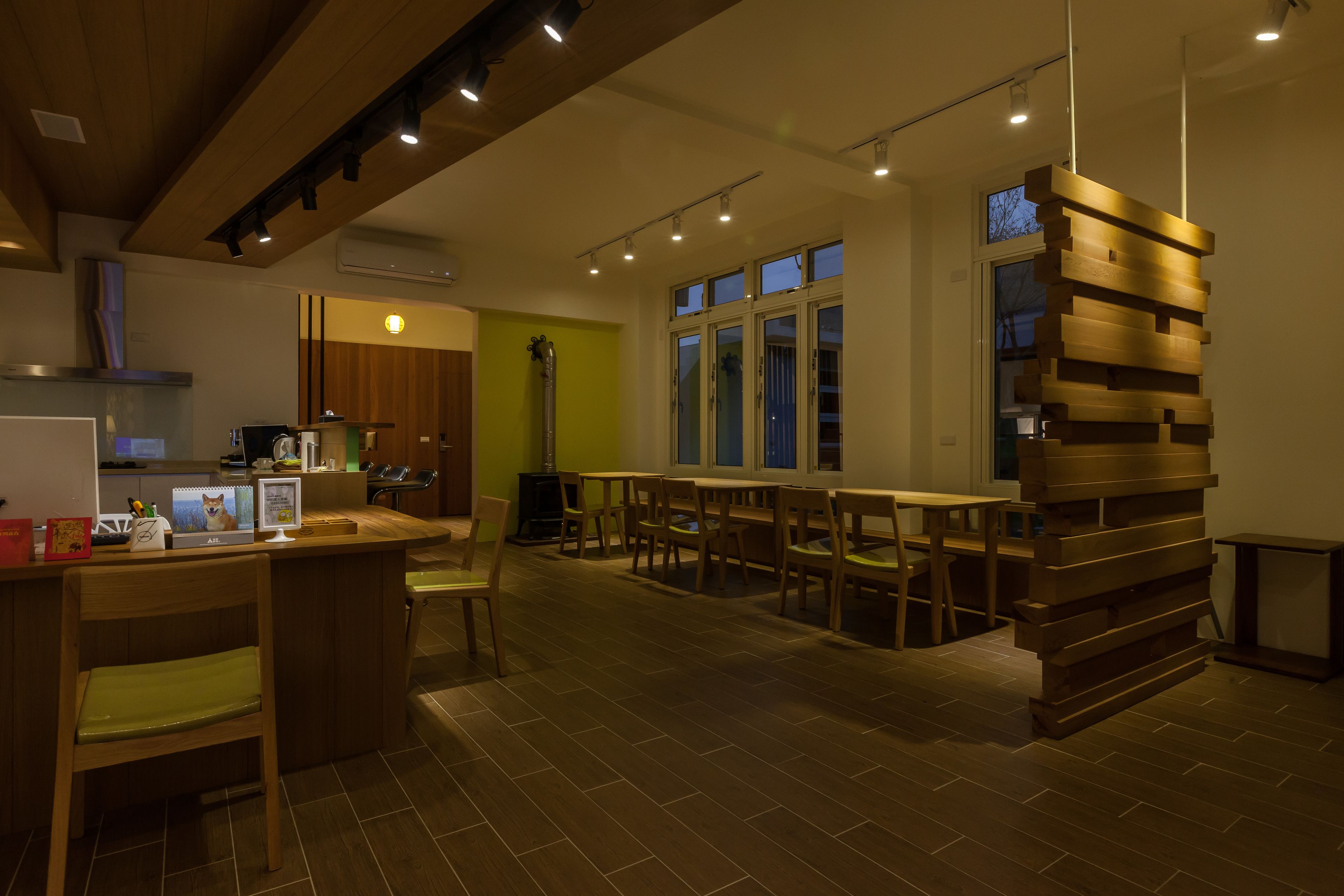 Una cocina amplia con muebles de madera, un comedor con mesas y sillas, y un ventanal que proporciona luz natural.