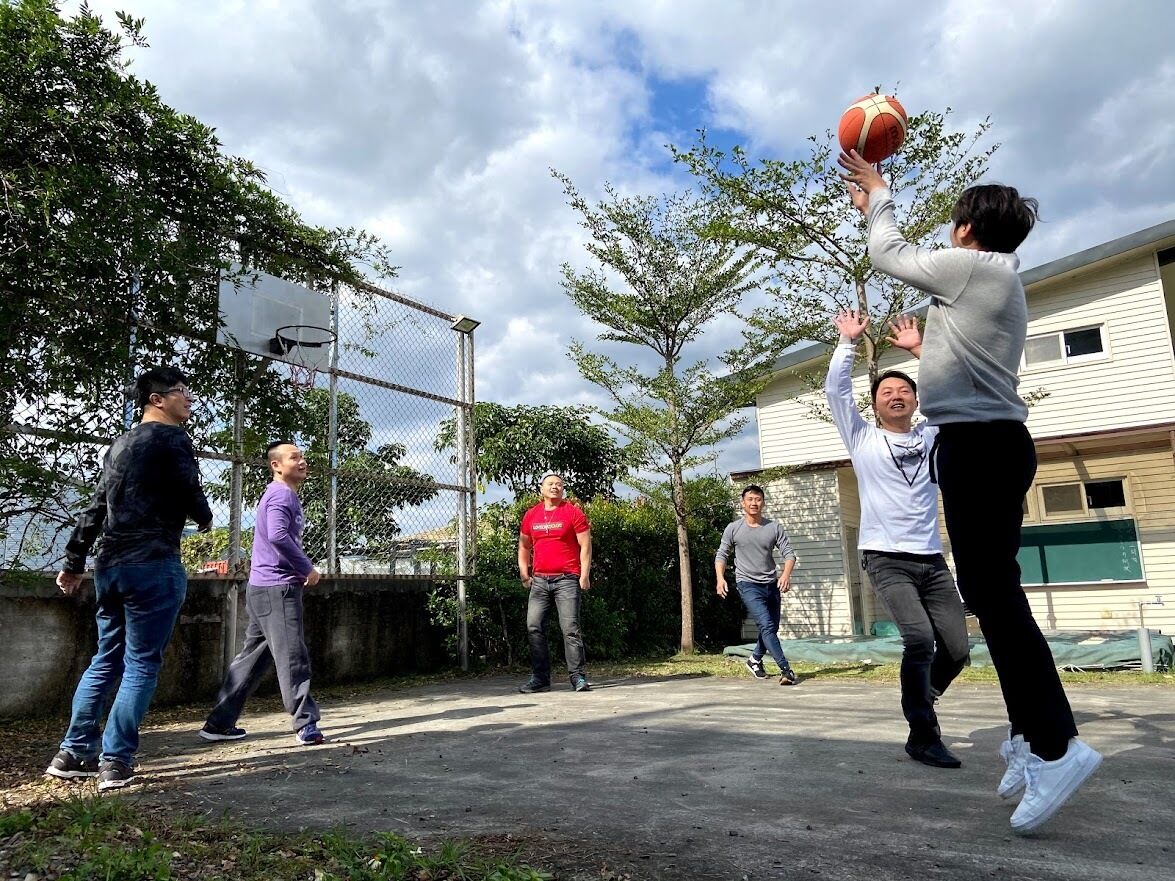 Un groupe de personnes jouant au basketball à l’extérieur.