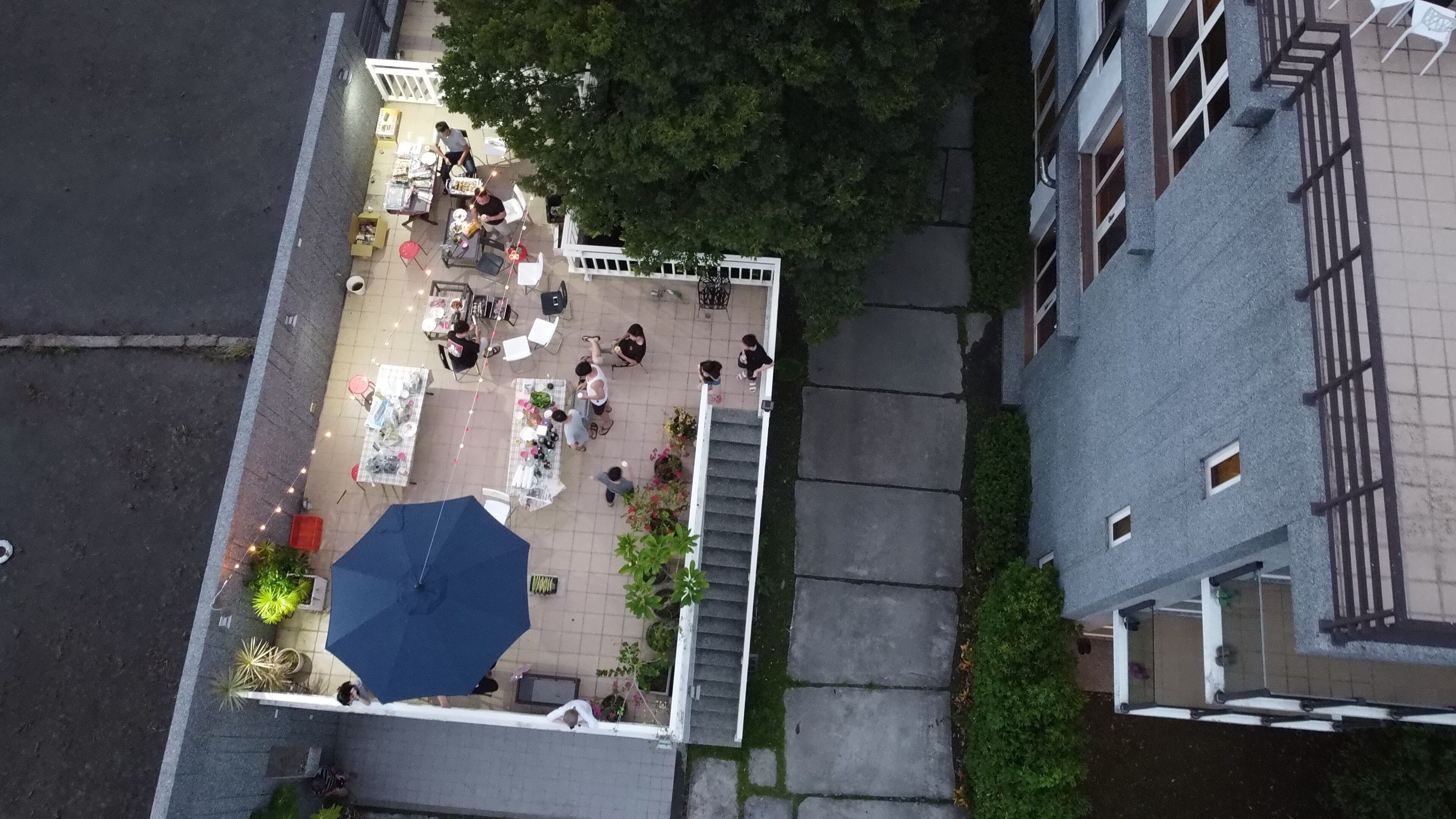 Vista aérea de un patio con asientos al aire libre, una escalera y un edificio con balcón.