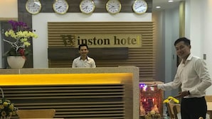 Una mesa de recepción con un letrero que dice 'Winston Hotel' y cuatro relojes encima.