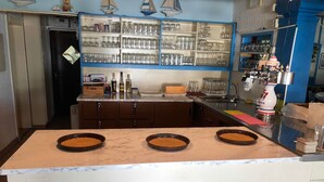 A kitchen with a marble countertop, a built-in oven, and a shelf with glassware. - Hotel Kreta (Ueberlingen)