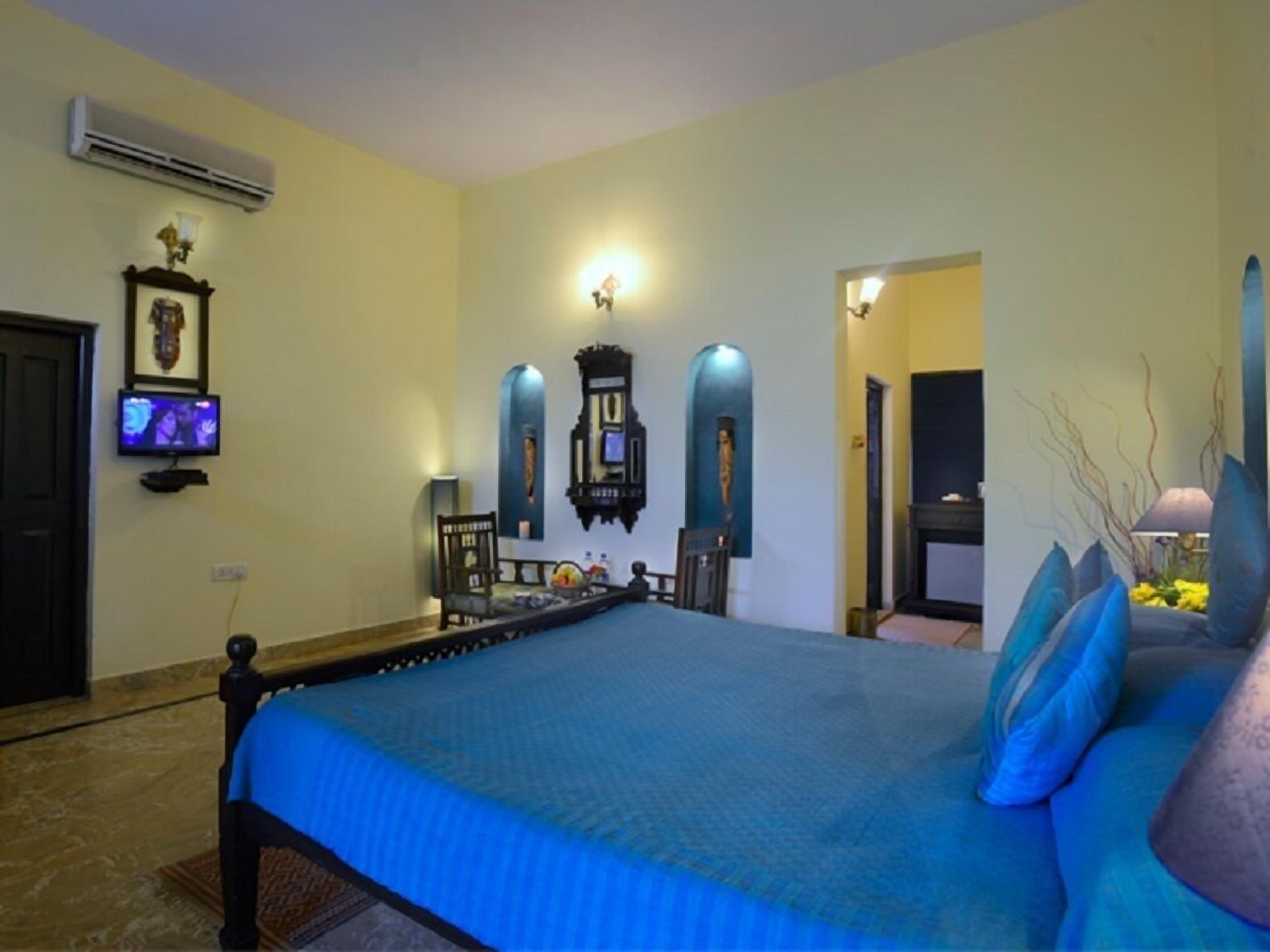 Un dormitorio con una cama grande, un televisor en la pared y un adorno decorativo.