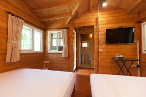 A wooden cabin room with two beds, a TV, and a bathroom visible through an open door. - Locasu B&B (Datong)