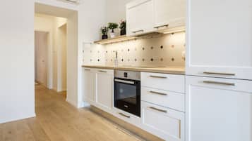 Design appartement | Privékeuken | Een koelkast, een magnetron, een oven, een kookplaat