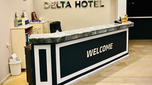 A reception desk with a 'WELCOME' sign, clocks displaying London, Istanbul, and Berlin, and a Delta Hotel logo. - Hotel Delta Altinkum (Didim)
