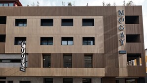 A modern hotel with a vertical sign reading 'MOGAY HOTEL' and a smaller sign indicating 'rooms & apartments.' - Hotel Mogay (Chantada)