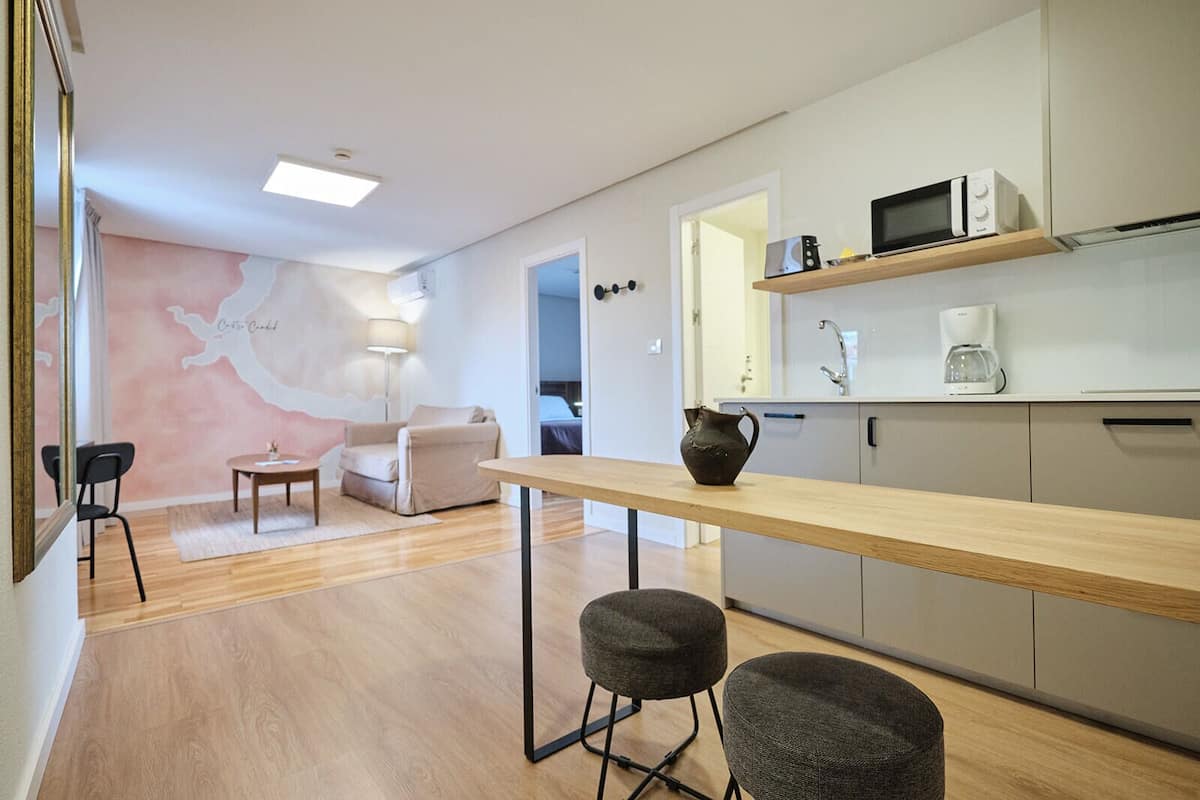 A modern kitchen with a wooden countertop, a microwave, a coffee maker, and a cabinet.