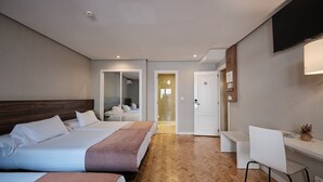 A hotel room with two beds, a desk, a chair, a TV, and a mirror. - Hotel Mogay (Chantada)