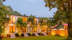 A modern two-story house with large windows, a well-maintained lawn, and a bamboo fence. - EKHO Weligama (Weligama)