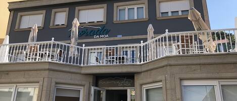 Un edificio con un balcón, un letrero que dice "Bodega da Moa" y una puerta con la inscripción "BODEGA Estrella Galicia".