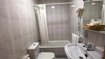 Un baño moderno con bañera, inodoro y lavamanos.