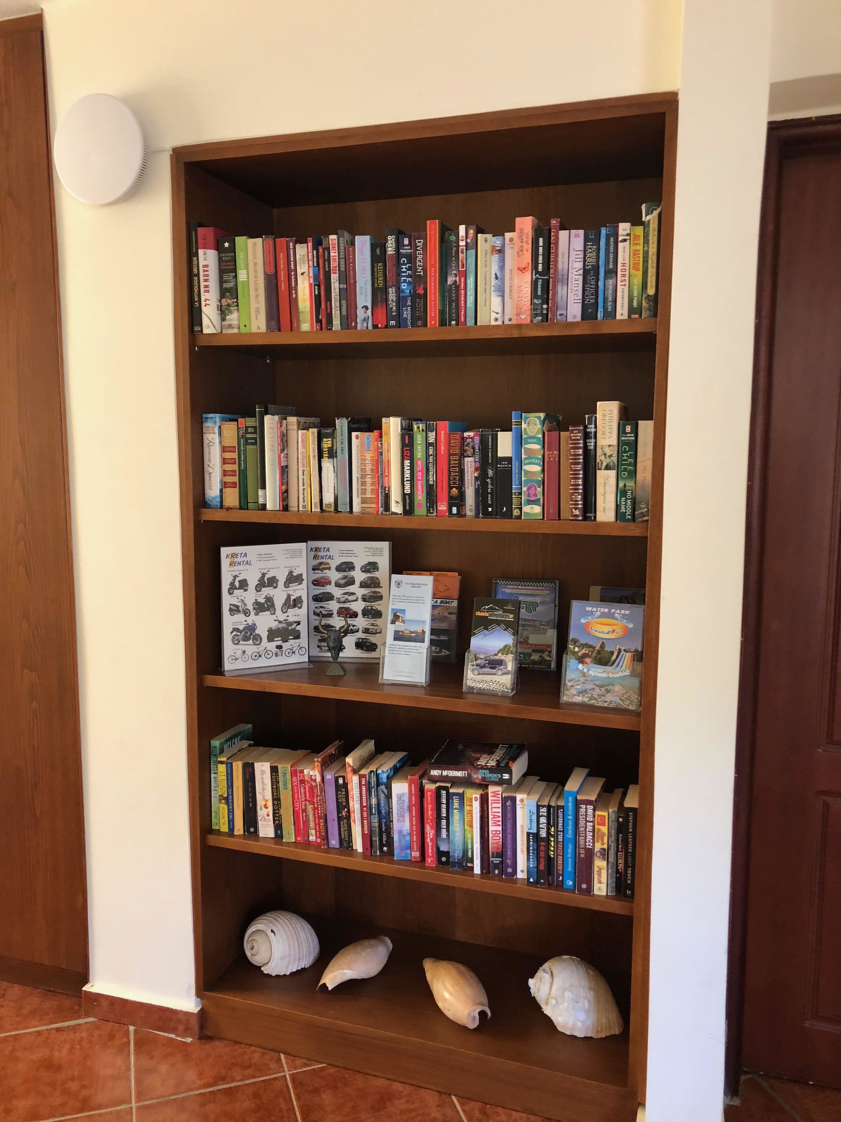 A bookshelf with various books and a rental sign.