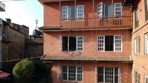 Un immeuble en briques à plusieurs étages, doté de nombreuses fenêtres et de balcons.