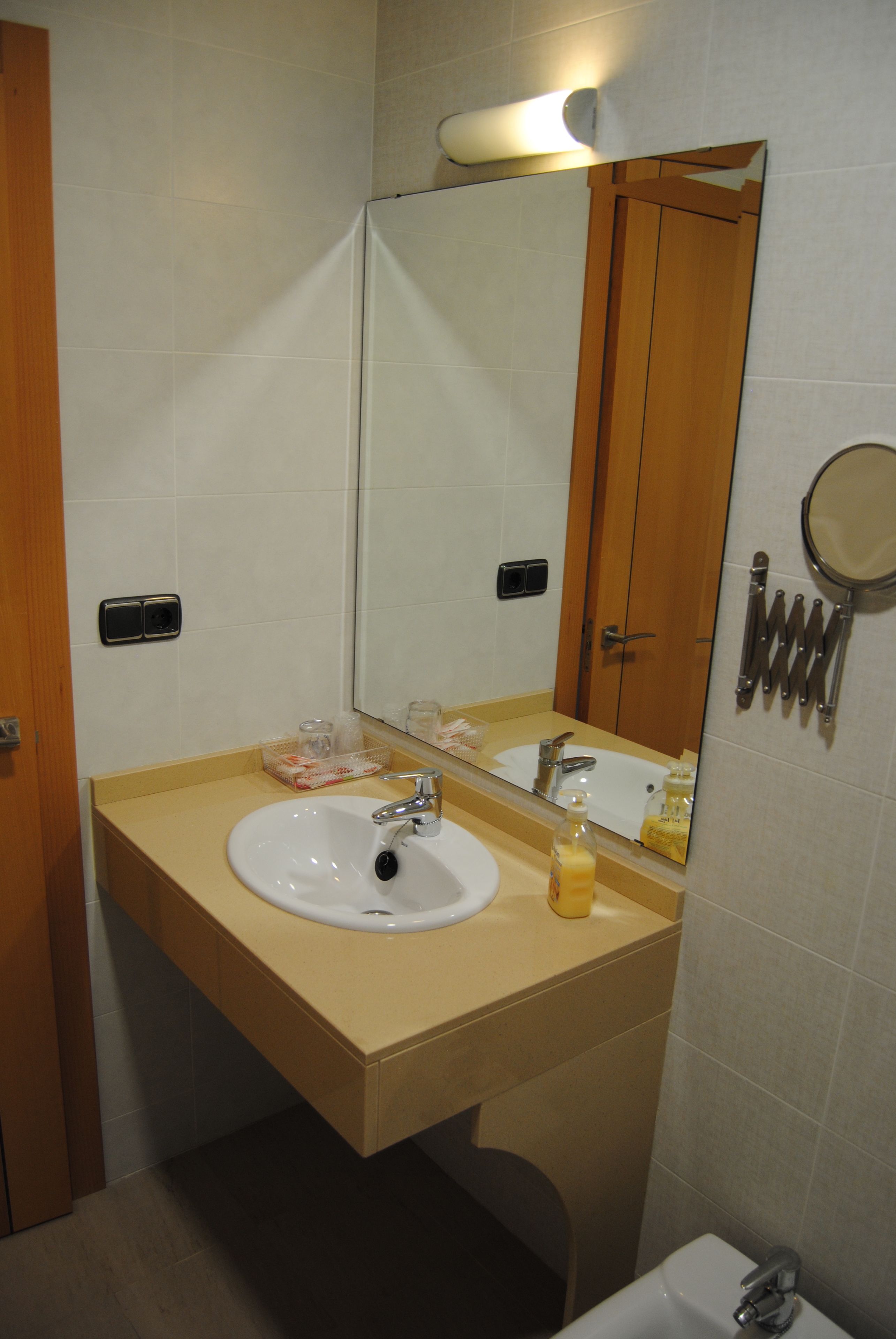 A bathroom with a sink, mirror, and toilet.