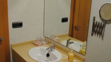 A bathroom with a sink, mirror, and toilet.