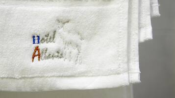 Une serviette blanche ornée d’un texte brodé et d’un logo.