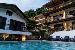 A hotel with a swimming pool, multiple balconies, and a staircase leading to the upper floors. - Altamare Dive and Leisure Resort Anilao (Mabini)