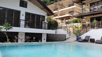 Alberca al aire libre y camastros