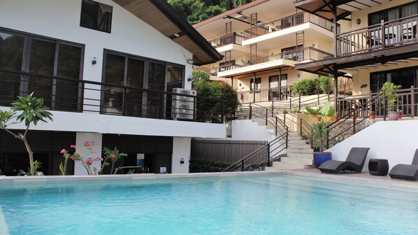 A hotel with a swimming pool, multiple balconies, and a staircase leading to upper floors. - Altamare Dive and Leisure Resort Anilao (Mabini)