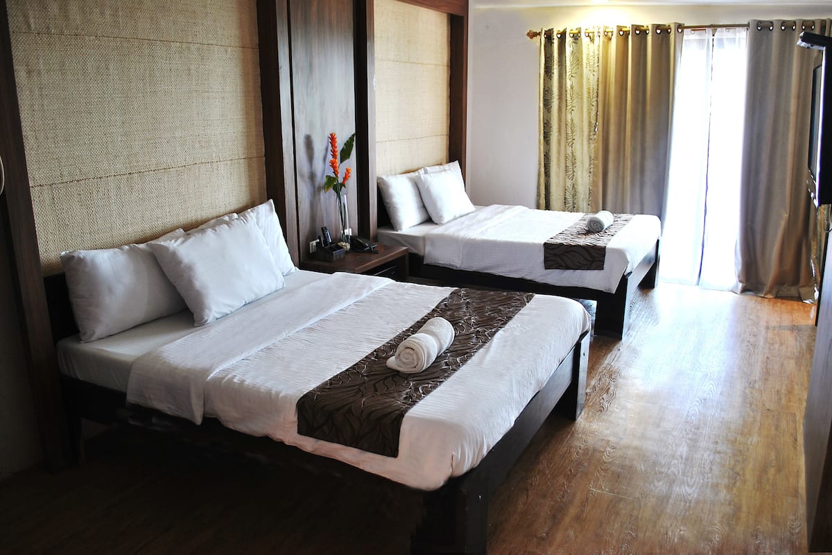 Two single beds with white linens and brown headboards in a hotel room.