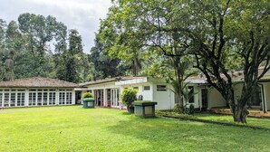 A building with a tiled roof, a covered patio area, and a well-maintained lawn. - Kitulgala Heritage Rest House (Kithulgala)