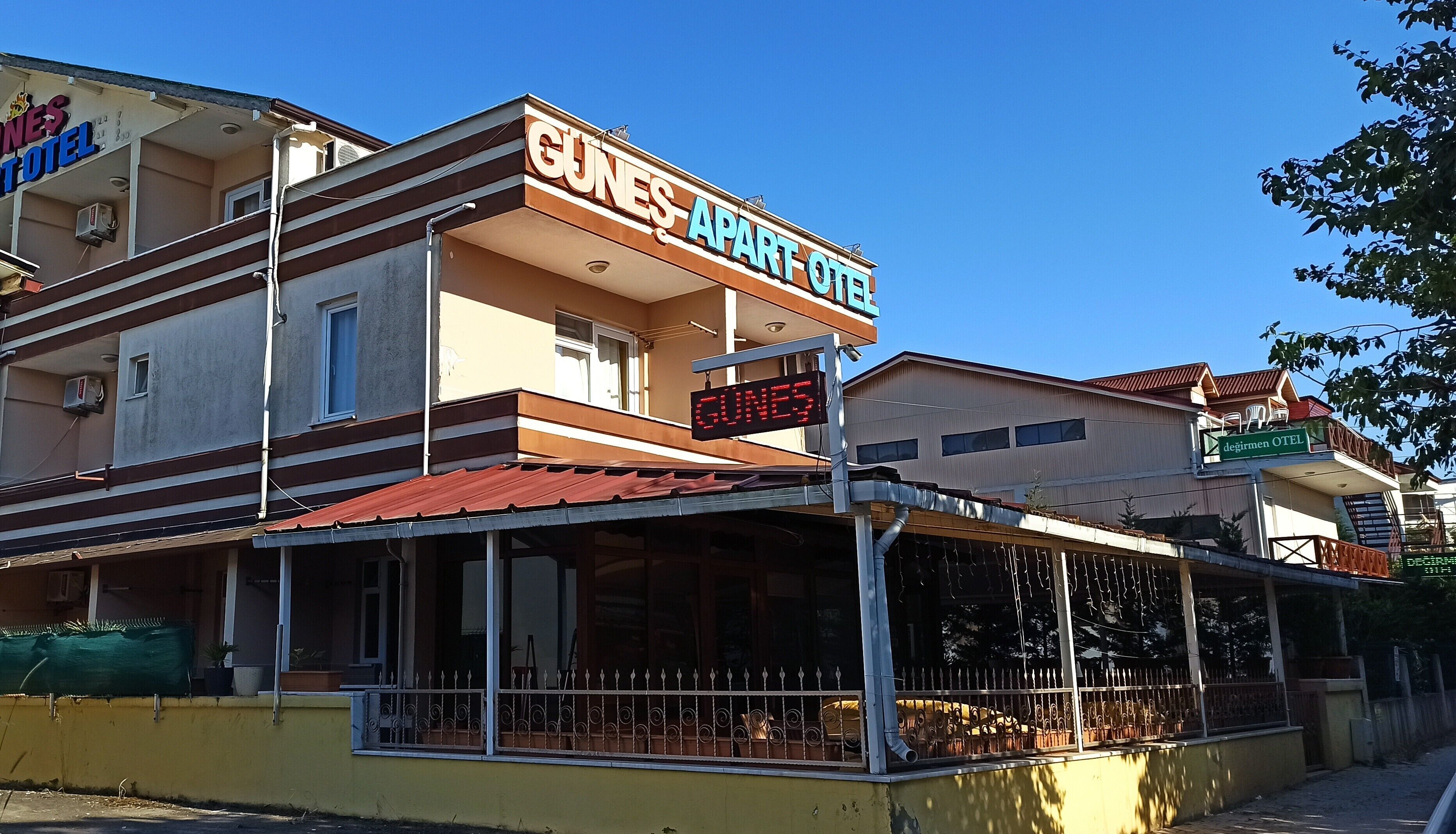 Un edificio de dos pisos con un letrero que dice "GUNES APART HOTEL".
