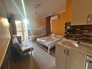 Quarto com beliches, pia e janela com cortinas.