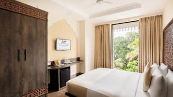 A hotel room with a bed, a desk, and a wardrobe.