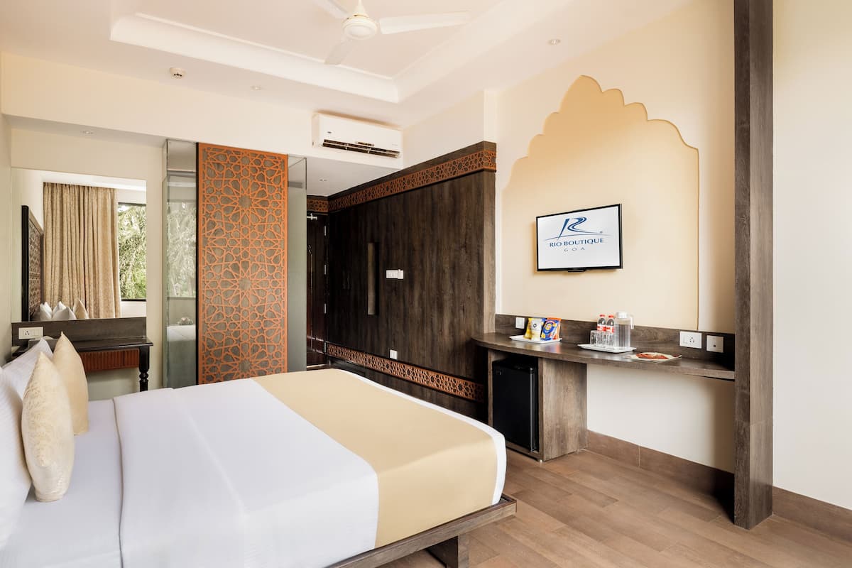 A hotel room with a bed, a desk, and a bathroom.
