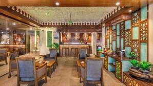 Ein Restaurant mit Holztischen, einer Bar und dekorativen Raumteilern.