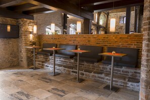 Un ristorante con pareti in mattoni, pavimenti in pietra e sedute moderne.