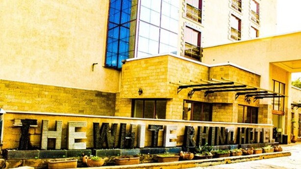 A hotel entrance with a stone facade and a sign spelling out the hotel's name.