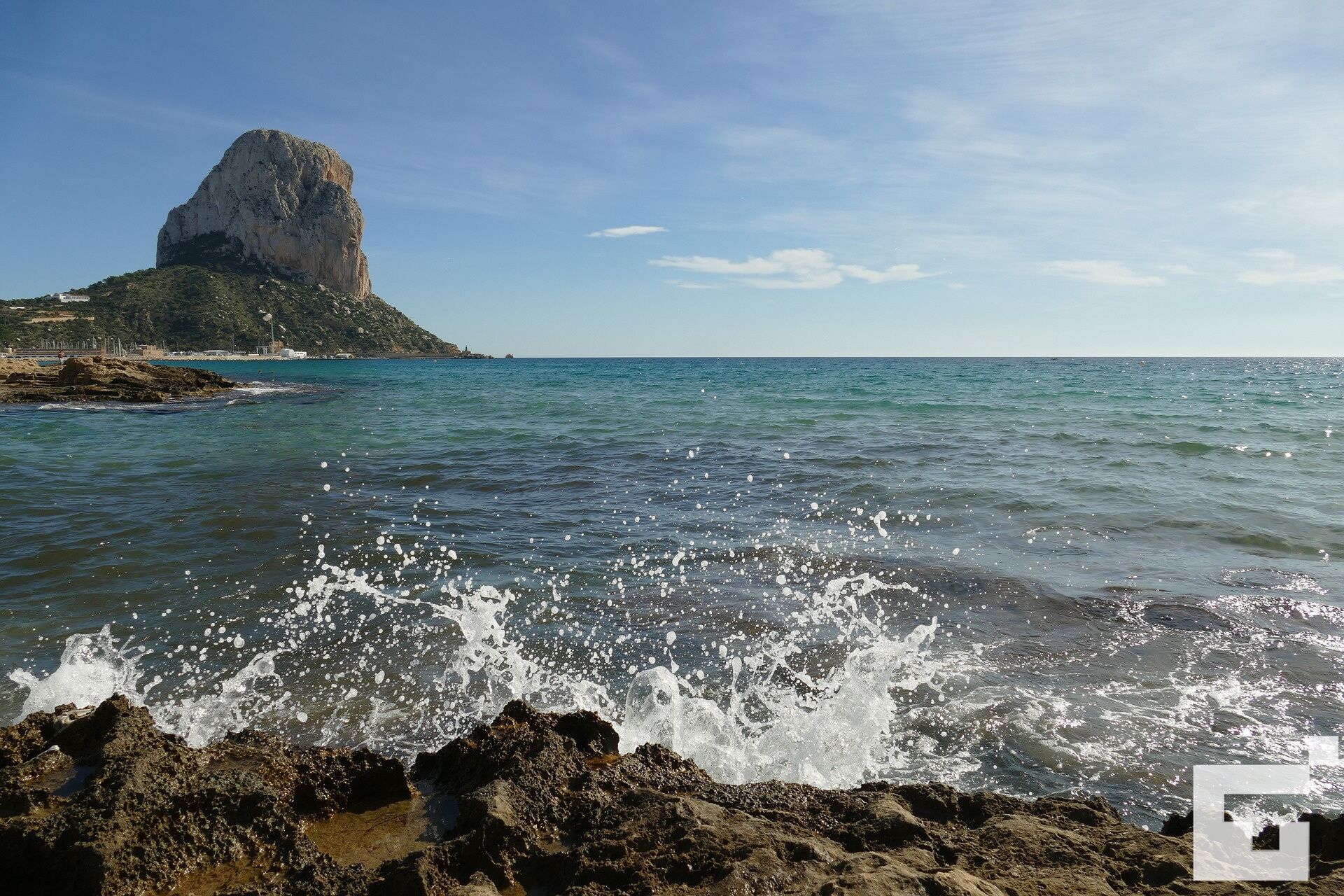 Una costa rocciosa con onde che si infrangono sulle rocce.