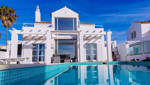 A white villa with a swimming pool, large windows, and a balcony. - Villa w/private pool in peaceful holiday complex (Albufeira)