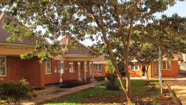 A residential building with a brick facade, a covered porch, and a well-maintained lawn. - Ulrika Guest House (Entebbe)